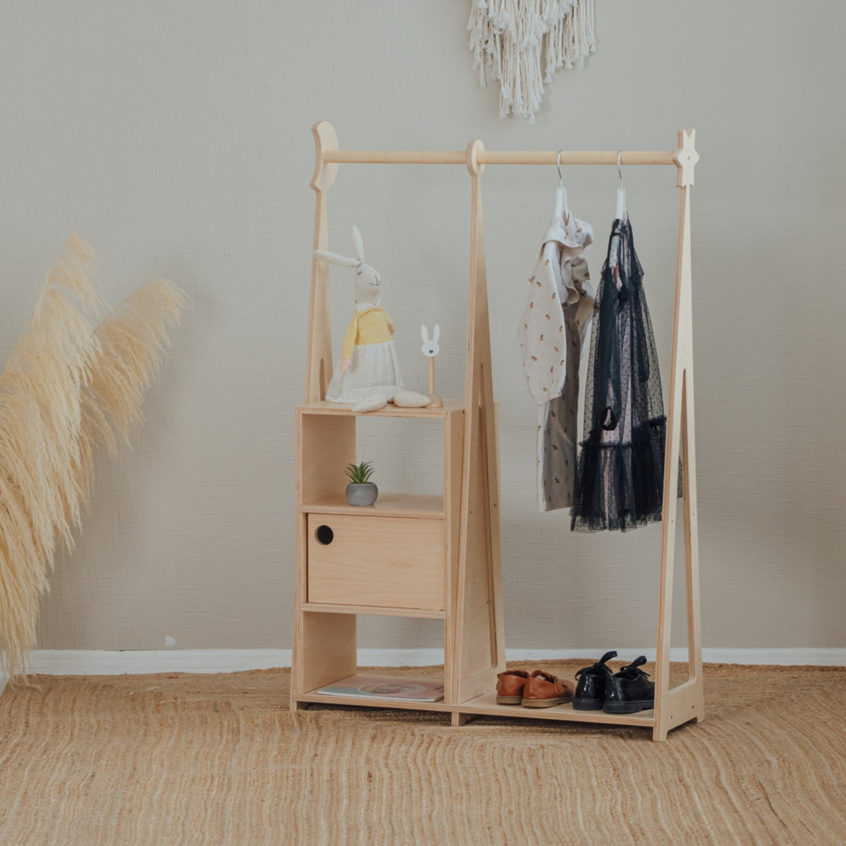 Child reaching clothes on the Montessori wardrobe's open rail